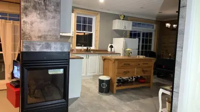 a kitchen with a black refrigerator and a counter at Gîte des étoiles in Notre-Dame-Des-Bois