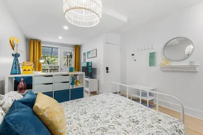 a white bedroom with a bed and a sink at Charming 1 BR Apartment cozy and fully equipped in Montréal
