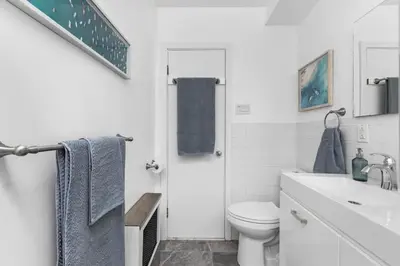 a white bathroom with a toilet and a sink at Charming 1 BR Apartment cozy and fully equipped in Montréal