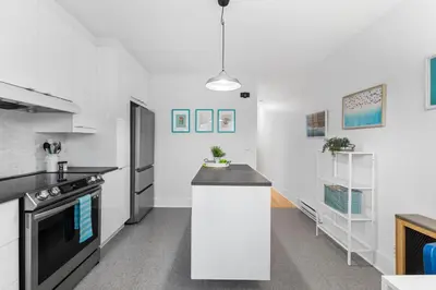a kitchen with white walls and a black counter top at Charming 1 BR Apartment cozy and fully equipped in Montréal