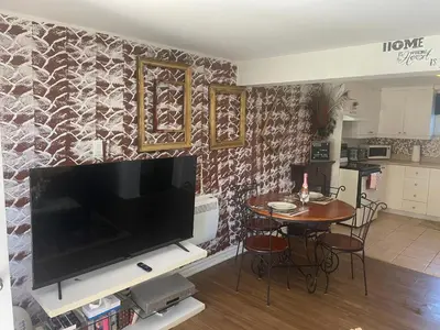 a living room with a television and a table with chairs at Havre de paix in Laval