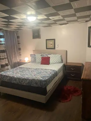 a bedroom with a bed with a red pillow on it at Havre de paix in Laval