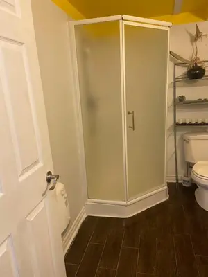 a bathroom with a toilet and a glass shower at Havre de paix in Laval