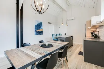 a kitchen and dining room with a wooden table and chairs at Complexe La Voûte by Gestion ELITE in Laval