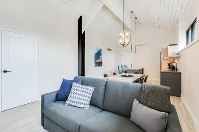 a living room with a blue couch and a kitchen at Complexe La Voûte by Gestion ELITE in Laval