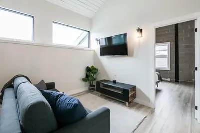 a living room with a couch and a flat screen tv at Complexe La Voûte by Gestion ELITE in Laval