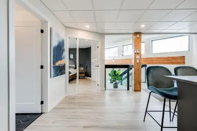 a living room with a table and chairs and a bedroom at Complexe La Voûte by Gestion ELITE in Laval
