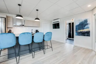 a kitchen with blue chairs and a counter at Complexe La Voûte by Gestion ELITE in Laval