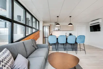 a living room with a couch and blue chairs at Complexe La Voûte by Gestion ELITE in Laval