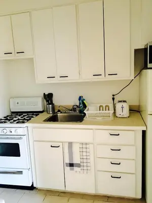 a kitchen with white cabinets and a sink at Stylish Montreal Apartment: Comfortable Stay in the Golden Square Mile in Montréal