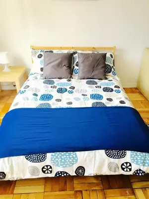 a bed with blue and white sheets and pillows at Stylish Montreal Apartment: Comfortable Stay in the Golden Square Mile in Montréal