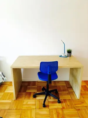a desk with a blue chair sitting in front of it at Stylish Montreal Apartment: Comfortable Stay in the Golden Square Mile in Montréal