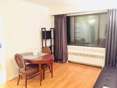 a dining room with a table and chairs and a window at Stylish Montreal Apartment: Comfortable Stay in the Golden Square Mile in Montréal