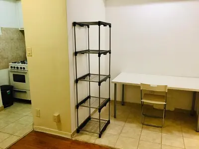 a kitchen with a shelf next to a table at Stylish Montreal Apartment: Comfortable Stay in the Golden Square Mile in Montréal