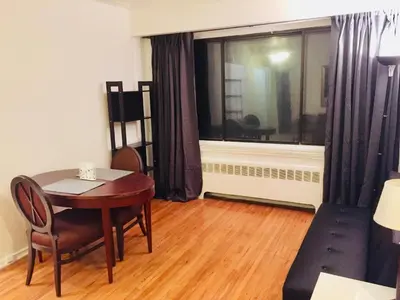 a room with a table and chairs and a window at Stylish Montreal Apartment: Comfortable Stay in the Golden Square Mile in Montréal