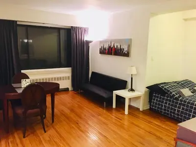 a living room with a couch and a bed and a table at Stylish Montreal Apartment: Comfortable Stay in the Golden Square Mile in Montréal