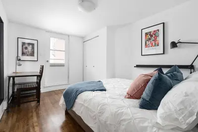 a white bedroom with a bed and a desk at Luxurious Old Montreal Parking Patio 10 Guests in Montréal