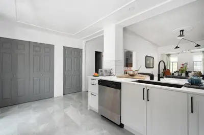 a white kitchen with white cabinets and a sink at Luxurious Old Montreal Parking Patio 10 Guests in Montréal
