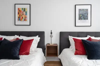 two beds with red and blue pillows in a bedroom at Luxurious Old Montreal Parking Patio 10 Guests in Montréal