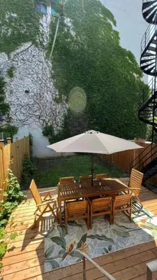 a wooden table with an umbrella on a patio at Luxury Old Montreal Parking with Yard Patio 10 Guests in Montréal