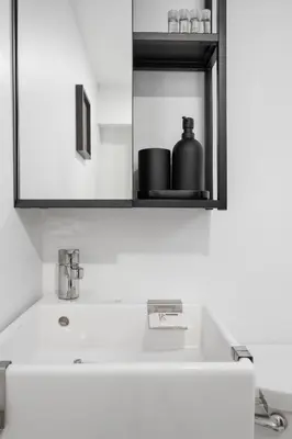 a bathroom sink with a black container on a shelf at Luxury Old Montreal Parking with Yard Patio 10 Guests in Montréal
