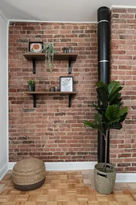 a brick wall with shelves and a potted plant at Luxury Old Montreal Parking with Yard Patio 10 Guests in Montréal