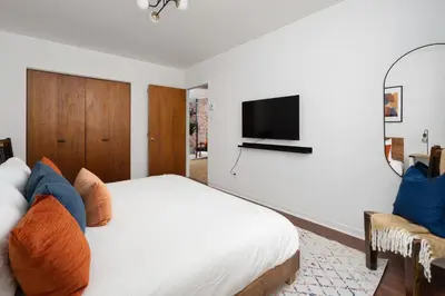 a bedroom with a bed and a tv on a wall at Luxury Old Montreal Parking with Yard Patio 10 Guests in Montréal