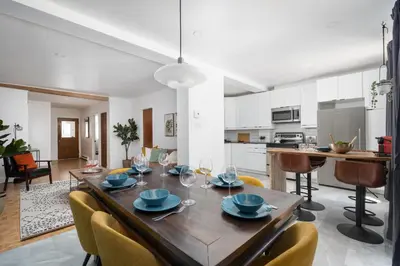 a dining room and kitchen with a wooden table and chairs at Luxury Old Montreal Parking with Yard Patio 10 Guests in Montréal