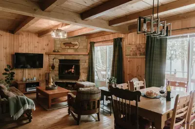 a dining room with a table and a fireplace at Le Sunset in Eastman