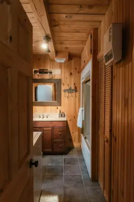 a wooden bathroom with a sink and a mirror at Le Sunset in Eastman