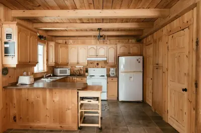 a kitchen with wooden cabinets and a white refrigerator at Le Sunset in Eastman