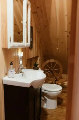 a bathroom with a sink and a toilet and a wheel at Le Sunset in Eastman