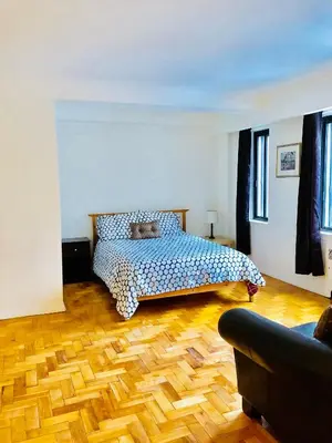 a bedroom with a bed and a wooden floor at Stylish Montreal Apartment: Comfortable Stay in the Golden Square Mile in Montréal