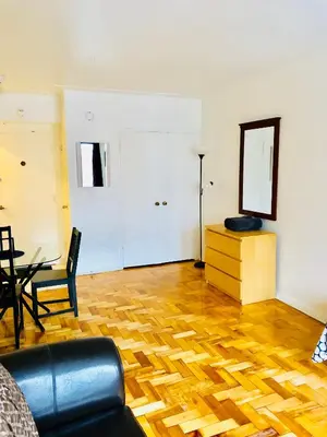 a living room with a table and a mirror at Stylish Montreal Apartment: Comfortable Stay in the Golden Square Mile in Montréal