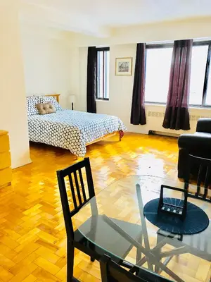 a living room with a bed and a glass table at Stylish Montreal Apartment: Comfortable Stay in the Golden Square Mile in Montréal