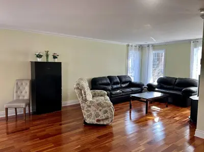 a living room with a black leather couch and chairs at 3BR House 6 Guests Near Water in Laval