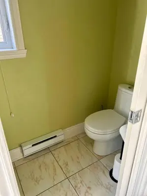 a bathroom with a toilet in a green wall at 3BR House 6 Guests Near Water in Laval