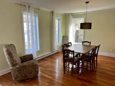 a dining room with a table and a chair at 3BR House 6 Guests Near Water in Laval
