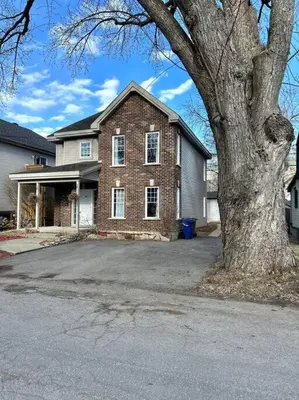 a brick house with a tree in front of it at 3BR House 6 Guests Near Water in Laval