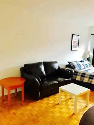 a black leather couch and a table in a living room at Stylish Montreal Apartment: Comfortable Stay in the Golden Square Mile in Montréal
