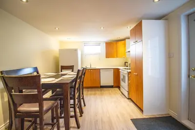 a kitchen and dining room with a table and chairs at L'Oasis Urbaine in Saint-Hubert