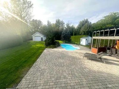 a backyard with a swimming pool and a building at L'Oasis Urbaine in Saint-Hubert