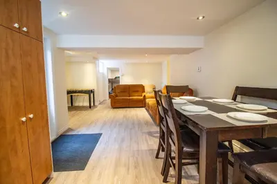 a dining room and living room with a table and chairs at L'Oasis Urbaine in Saint-Hubert