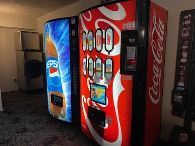two vending machines are next to a soda machine at Travelodge by Wyndham Drummondville in Drummondville