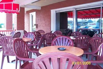 a row of wooden tables and chairs on a patio at Travelodge by Wyndham Drummondville in Drummondville