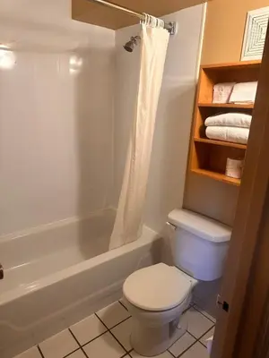 a bathroom with a toilet and a tub and a shower at Travelodge by Wyndham Drummondville in Drummondville