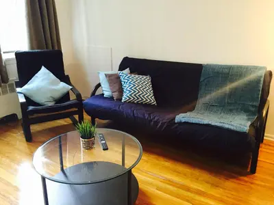 a living room with a couch and a glass table at Stylish Montreal Apartment: Comfortable Stay in the Golden Square Mile in Montréal