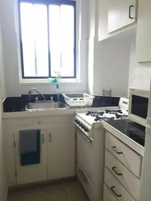 a kitchen with a stove and a sink and a window at Stylish Montreal Apartment: Comfortable Stay in the Golden Square Mile in Montréal
