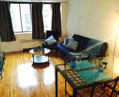 a living room with a couch and two tables at Stylish Montreal Apartment: Comfortable Stay in the Golden Square Mile in Montréal