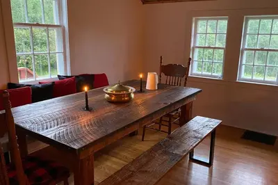 a living room with a wooden table with candles on it at Le Highwater - Cabin in Mansonville